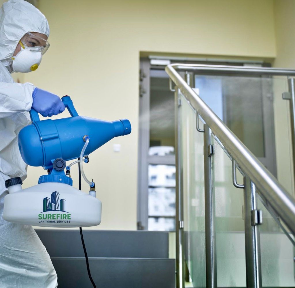 Technician fogging a stairwell with a Surefire Janitorial Services disinfectant sprayer