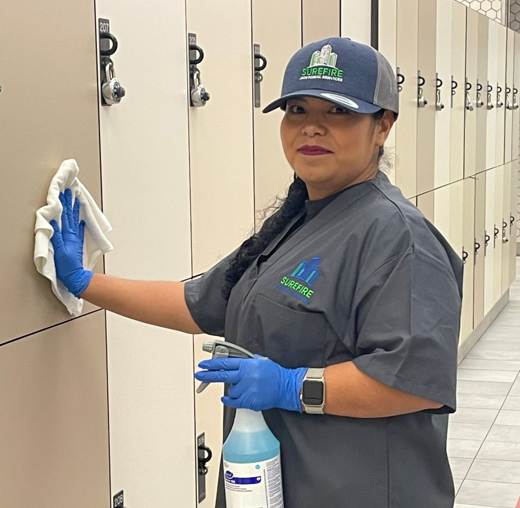 Surefire Janitorial Services team member in uniform wiping down lockers